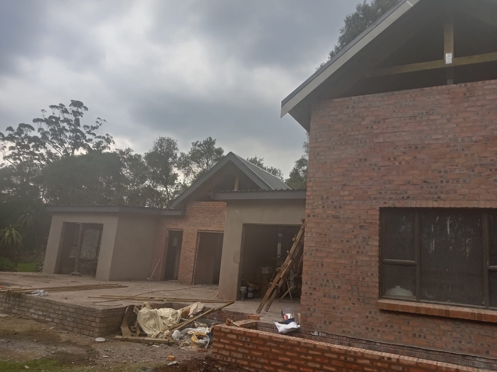 Side view of a residential build with brick walls and metal roof sheets