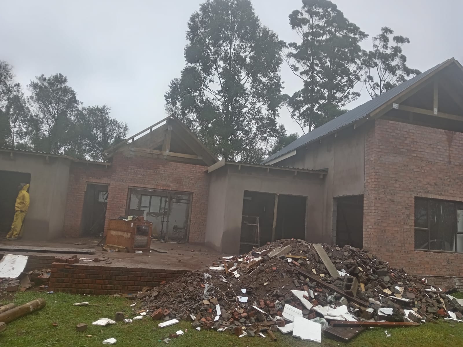 House under construction with exposed brickwork, plastered walls and pitched roofs
