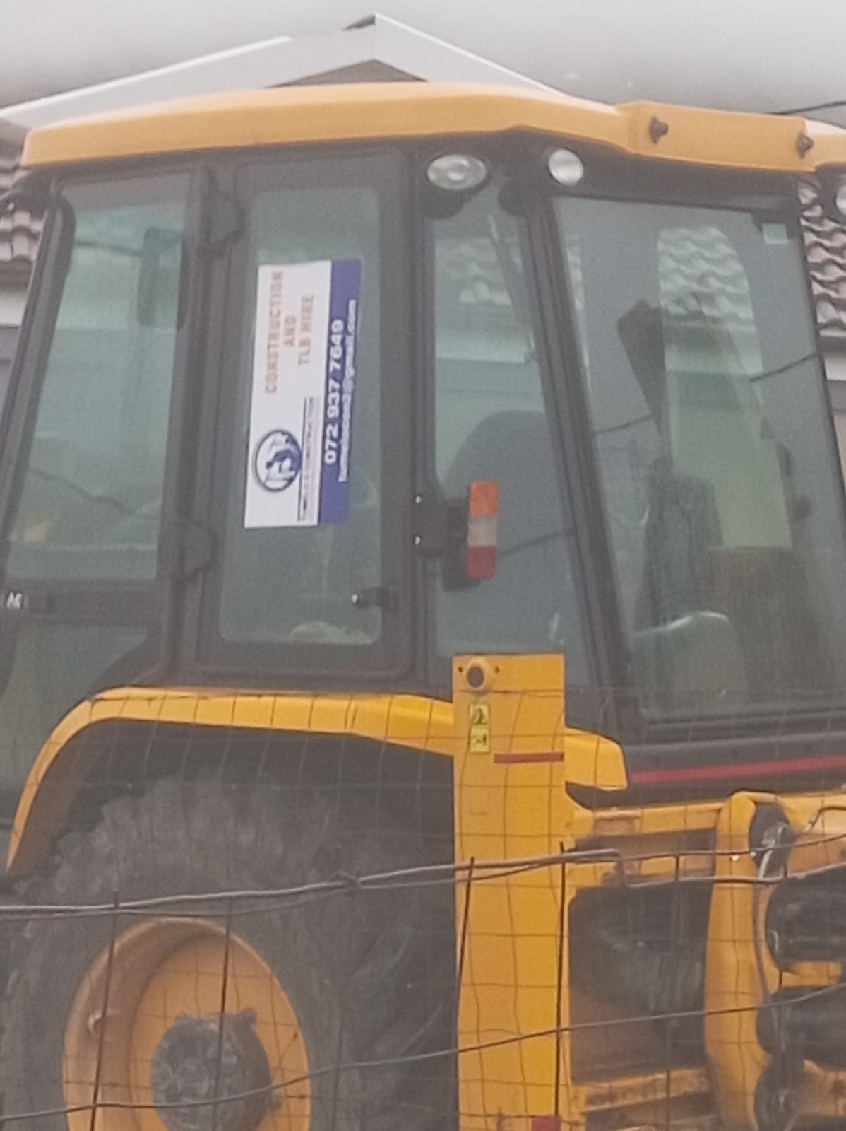 Yellow construction vehicle displaying Tumelo construction branding